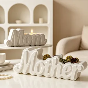 Close-up detail of white Mom and Mother letter candle holders and decor pieces in cozy room.