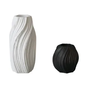 Detail shot of minimalist twisted ripple texture vases, featuring a tall white and short black