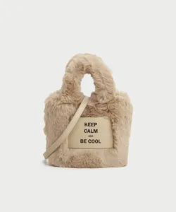 Detailed view of stylish autumn winter fluffy plush bucket bag with leather strap.