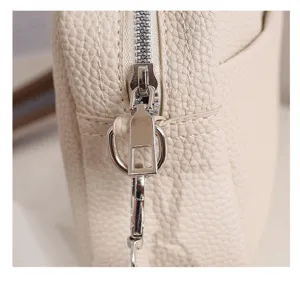 Detailed close-up view of women's beige PU leather crossbody bag with metal zipper.
