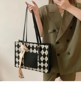 Detailed view of the black and white argyle tote bag, showing spacious design and stylish ribbon.
