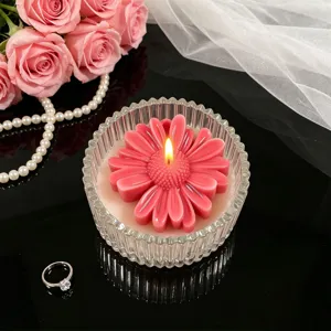 Detailed close-up of a floral scented candle in fluted glass cup with decorative setup.