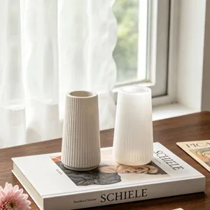 Detail shot of minimalist striped desk vase and pen holder set on wooden table with curtain.