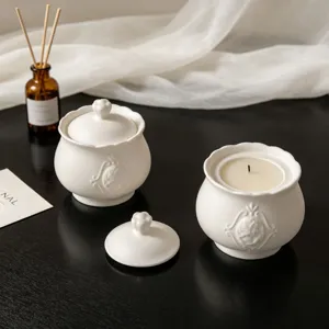 Barattolo in ceramica goffrata vintage con coperchio e candela profumata dal design in rilievo.