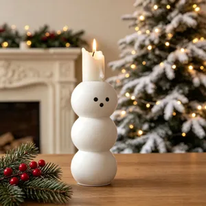 Dettagli del candelabro a forma di pupazzo di neve sferico bianco in un'atmosfera natalizia.
