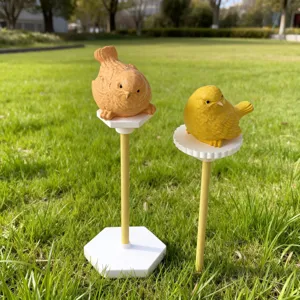 Outdoor garden bird display stands with cute figurines set on a lush green lawn view.