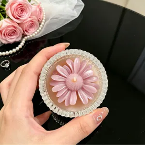 Pink daisy scented candle in ribbed glass jar, elegant home decor item for any room.