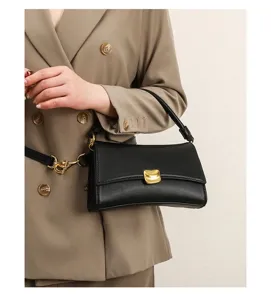Black underarm baguette bag detail, stylish women shoulder handbag with gold metal buckle.
