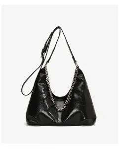 Glossy black hobo bag detail featuring a bold metallic chain and adjustable shoulder strap.