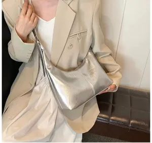 Silver metallic slouchy underarm hobo bag detail shot showing soft leather texture.