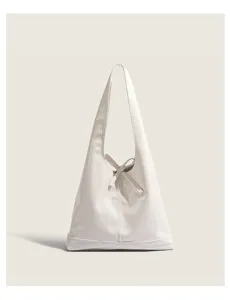 White minimalist shoulder bag detail, stylish triangular hobo design with strap accent.