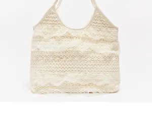 Vue détaillée du sac porté épaule en dentelle tissée, montrant la texture délicate et les volants.