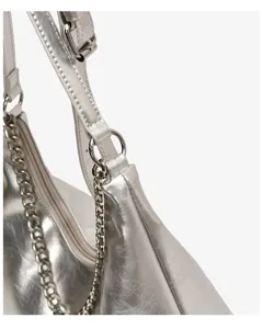 Detail view of stylish metallic silver shoulder bag with chain strap and leather material.