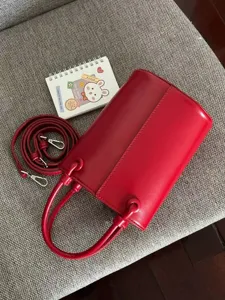 Stylish red leather bucket bag with handle and strap detail shot fashion accessory