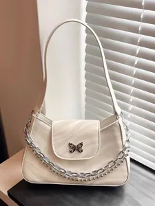 White shoulder bag featuring silver chain and cute butterfly metallic clasp detail.