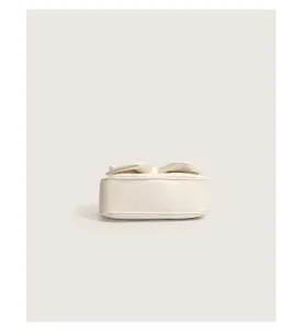 Detailed view of white minimalist women shoulder bag with elegant bow design for autumn style.