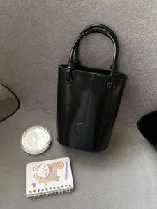 Minimalist black bucket bag for women, stylish dual-handle handbag for autumn and winter.
