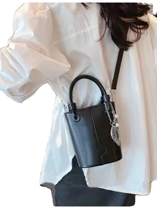 Fashion black bucket bag for women, minimalist crossbody handbag with chic leaf charm.