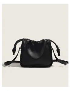 Close-up detail of the black gathered shoulder bag showing unique side knots and texture.