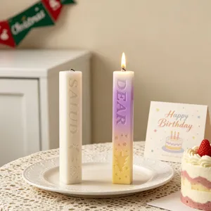Detailed view of scented pillar candles with embossed letter designs, aesthetic home decor.