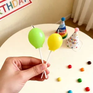 Cute balloon shaped birthday candles in green and yellow with sticks for parties.
