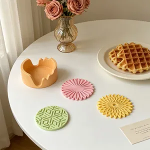 Vue détaillée des moules de sous-verre en silicone fleur et flocon avec base de rangement.