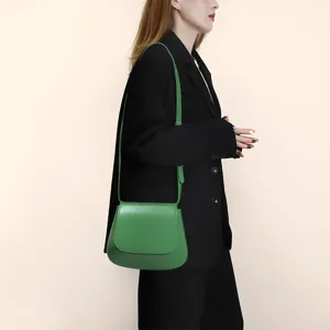 Detail shot of the green PU leather saddle bag, highlighting smooth leather texture and strap.