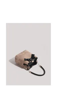 Detailed view of the vintage khaki bucket bag featuring elegant black bow and woven handle.