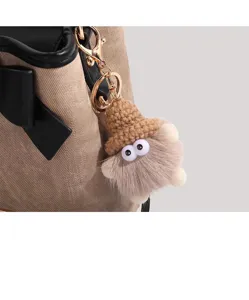Detailed view of vintage bucket bag and cute plush pendant, exquisite craftsmanship and style.