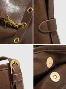 Brown leather tote bag detail shot showing vintage metal hardware and magnetic snap.