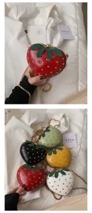 Cute heart-shaped strawberry crossbody bag with metal chain and rivet decor for women.
