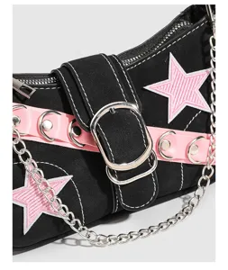Close-up detail of Y2K black shoulder bag with pink star patch and metal chain.