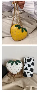 Close-up detail of the cute strawberry shaped chain bag with metal studs and leaf decor.