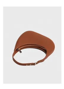 Detailed view of the brown crescent underarm bag, featuring smooth curves and sleek metal hardware.