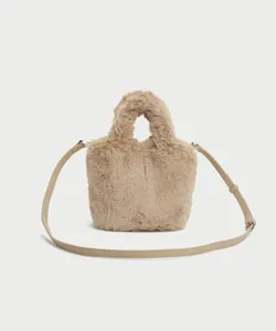 Close-up detail of soft khaki plush handbag, fluffy texture with adjustable shoulder strap.
