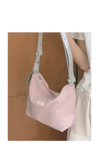 Detail shot of the pink canvas underarm bag, showing smooth zipper and adjustable strap.