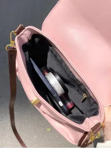 Pink leather shoulder bag interior capacity detail featuring soft material and brown straps.