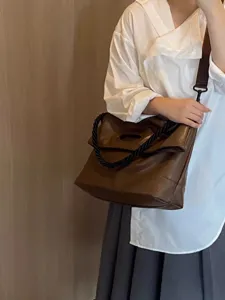 Detail shot of brown soft leather shoulder tote bag for women, large capacity commuter bag.
