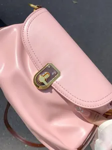 Pink soft leather shoulder bag detail, elegant pleated design and metal lock closure.