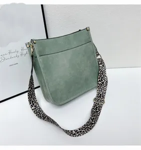 Green single shoulder bucket bag with trendy leopard print wide strap and metal hardware.