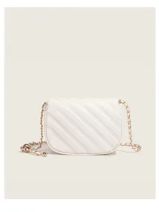White quilted crossbody bag detail, featuring elegant gold chain strap and chic metal ball.