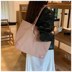 Detail view of a large pink shoulder tote bag for daily commuting, showing stylish design.