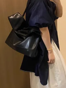 Detailed view of black soft leather slouchy shoulder tote bag, minimalist daily accessory.