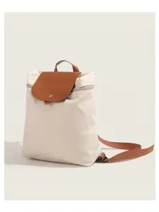Detailed view of the casual nylon backpack featuring a brown leather flap and adjustable straps.