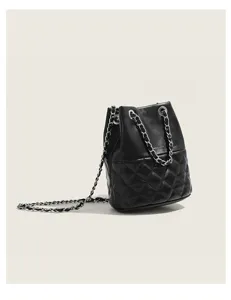 Detail view of the black quilted bucket bag featuring elegant chain strap and leather.