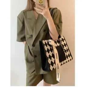 Stylish black and white argyle tote bag with ribbon detail, perfect for office commuting.