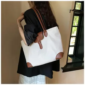 Detailed view of the chic two-tone commuter tote bag, featuring stylish brown leather trim details.