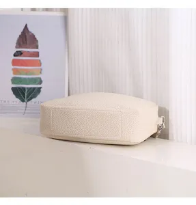 Beige pebbled PU leather crossbody bag, compact square design with textured finish and hardware.