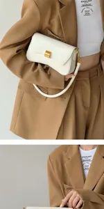Detailed view of minimalist urban shoulder baguette bag, featuring clean lines and gold hardware.