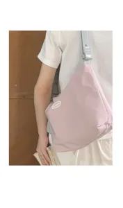 Canvas shoulder bag detail showing pink triangular design, trendy minimalist style.